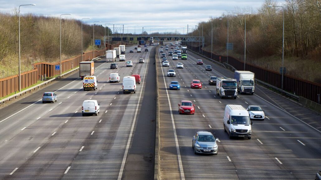 Cars, vans and lorries travelling on a three-lane motorway on a clear winter day